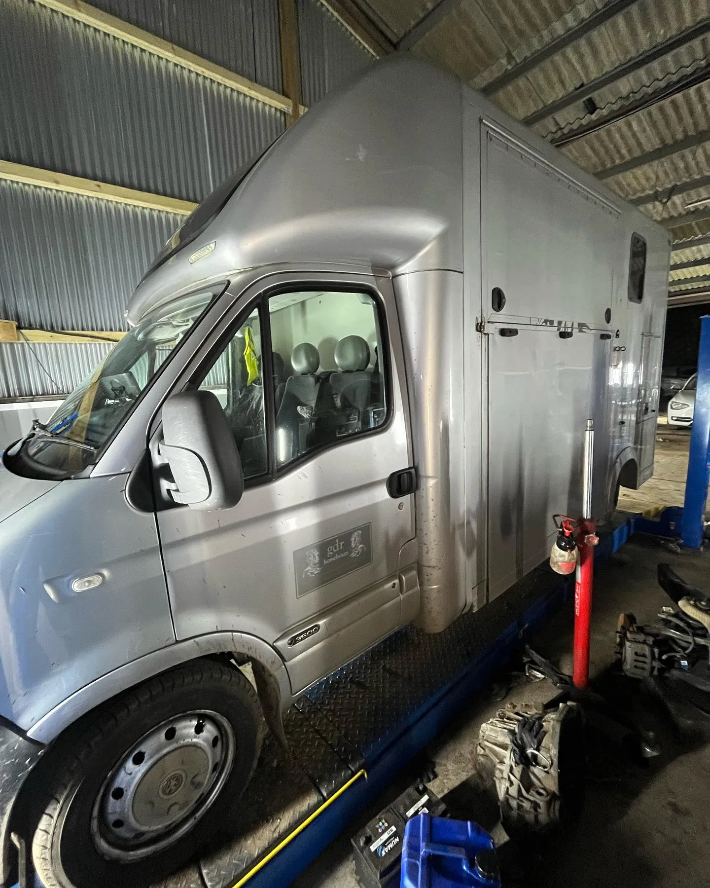A silver van is parked in a garage.