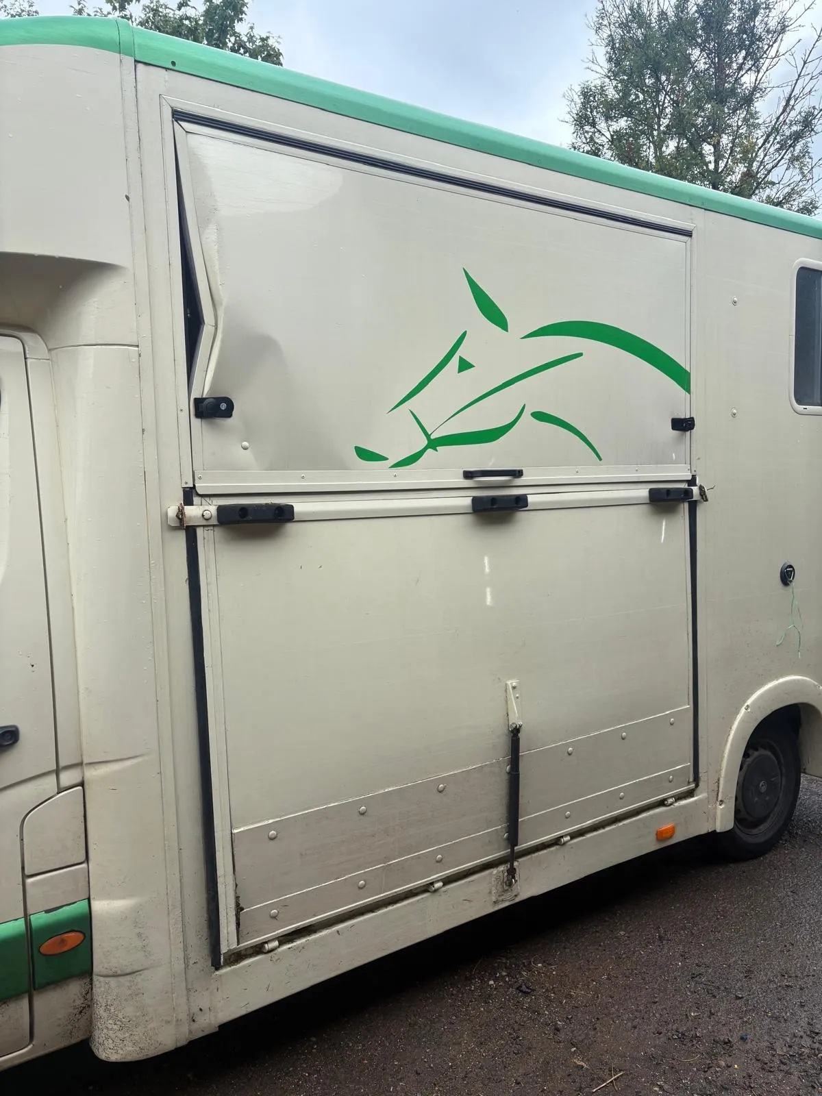 A horse trailer parked on the side of the road.