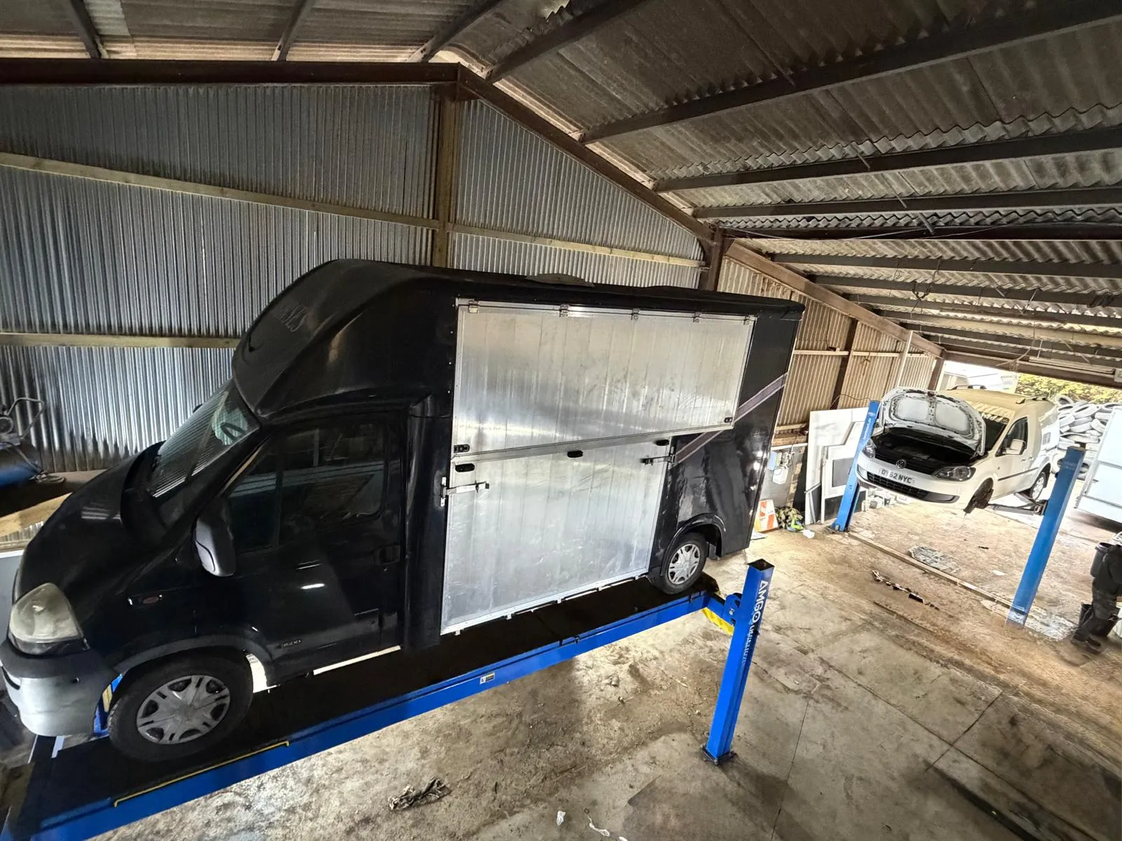 A small black van parked in a garage.