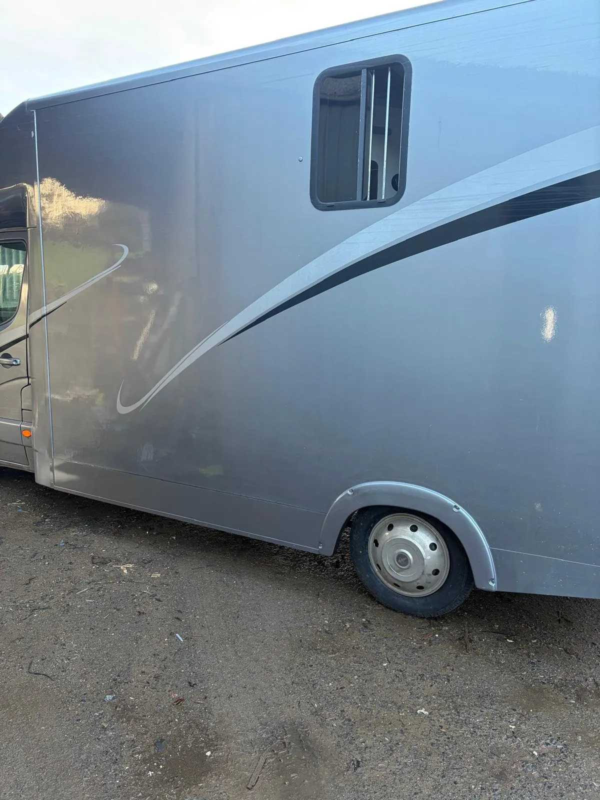A silver trailer parked in a parking lot.